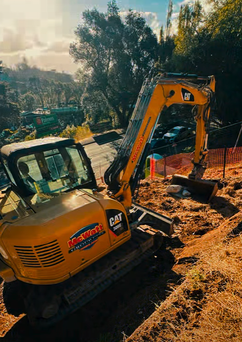 CAT excavator digging on a residential hillside site